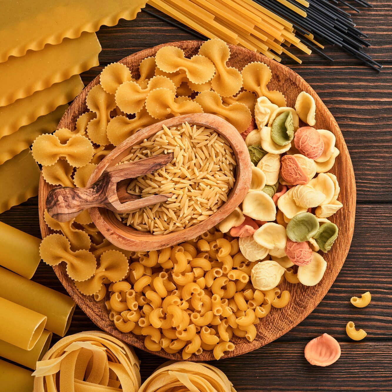 Variety of traditional italian pasta: colorful spaghetti, tagliatelle, farfalle, penne, ptititm, noo